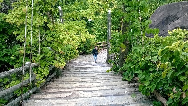 Bạn phải đi bộ qua hơn 1.000 bậc thang đá phía sau chùa hoặc thuê xe ôm men theo con đường nhựa để lên đỉnh