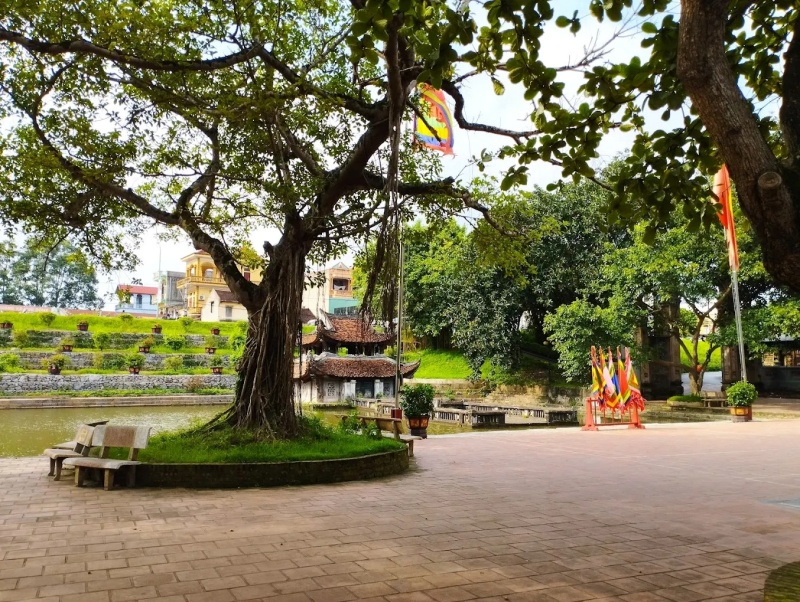 Không gian bên ngoài đền Gióng Phù Đổng có sân gạch rộng, hồ nước và cây cổ thụ, tạo sự thoáng đãng trước khi bước vào các cung thờ