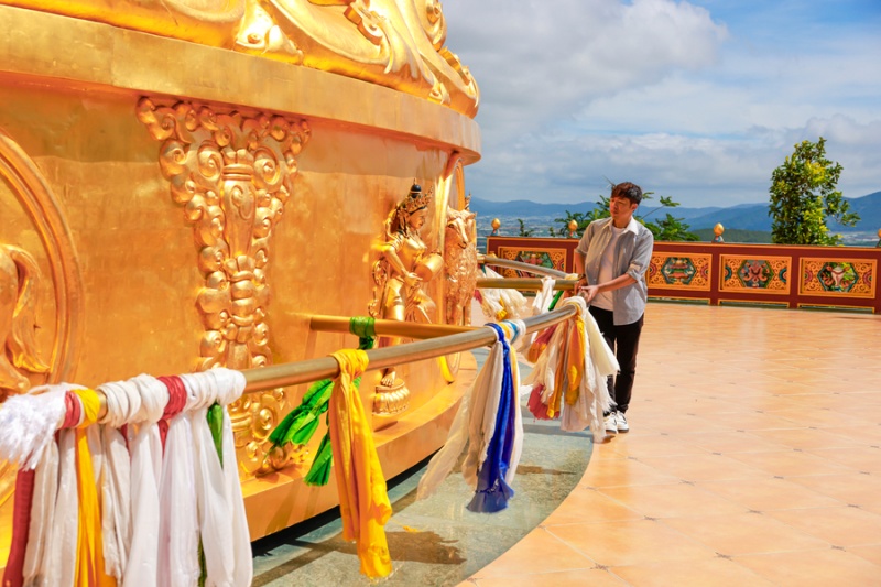 Khi đến Đại bảo tháp kinh luân, du khách có thể đặt tay lên thanh vịn kim loại và dùng sức đẩy tháp theo chiều kim đồng hồ