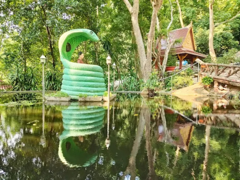 Tượng Đức Phật ngồi thiền tr&ecirc;n th&acirc;n cuộn tr&ograve;n của Thần rắn Naga tại một hồ nước nhỏ