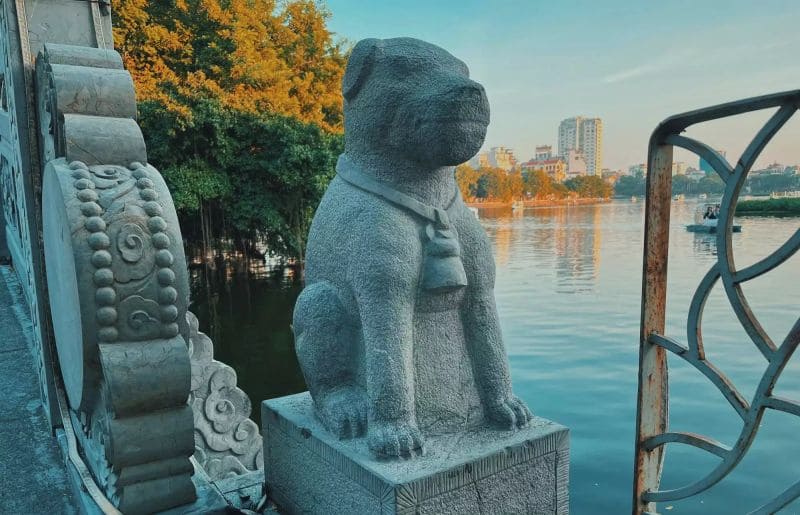 Bức tượng chó đá nhỏ được đặt ngay phần đầu cầu đá đóng vai trò làm linh vật dẫn lối, canh gác cho đền